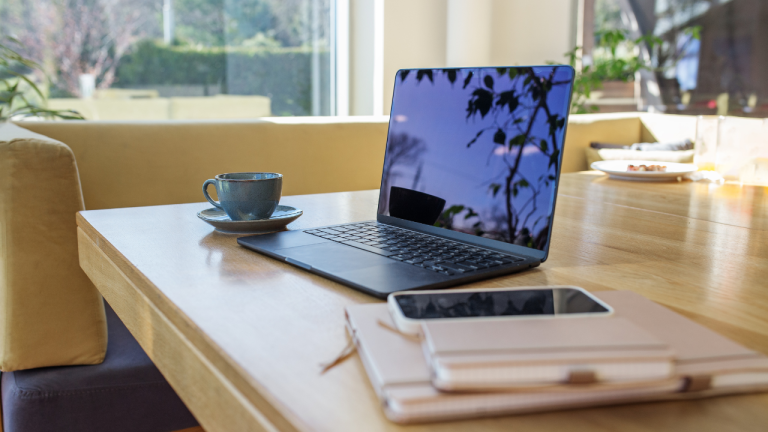 Ordenador portátil sobre una mesa junto a una ventana