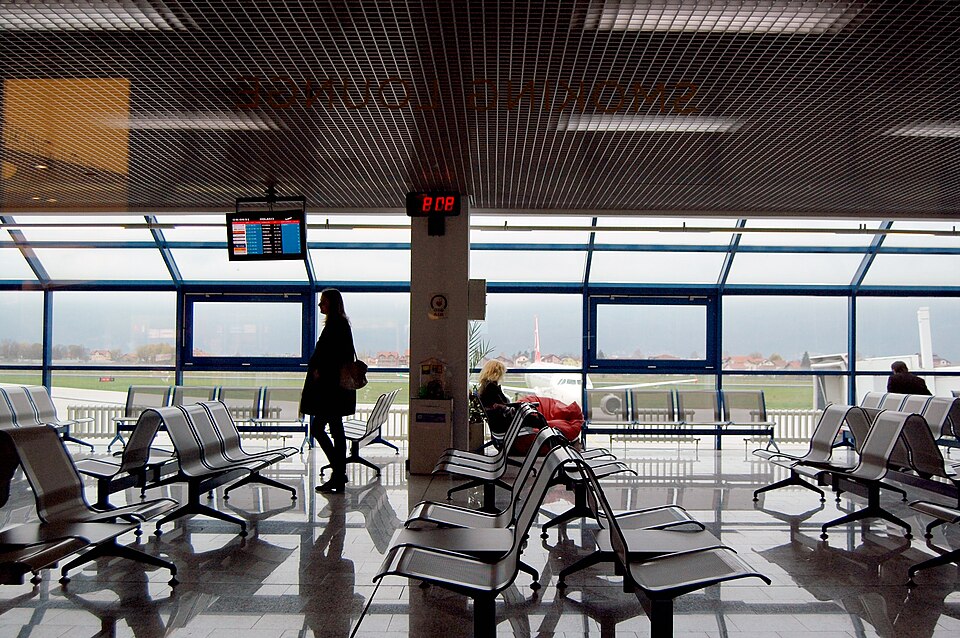 Zona de asientos y mesas dentro de una terminal aeroportuaria