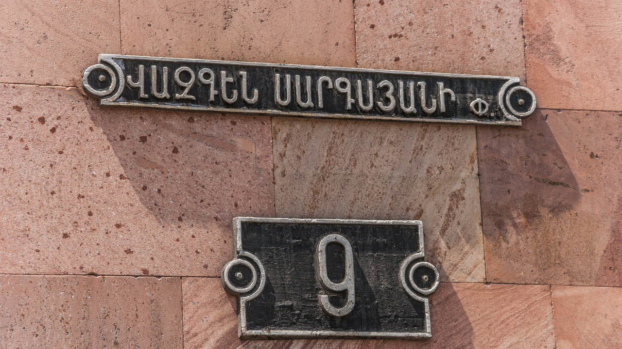Placa escrita en alfabeto georgiano en una fachada