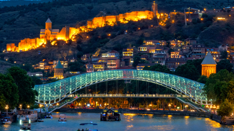 Vista nocturna del río y el puente de la Paz en Tiflis