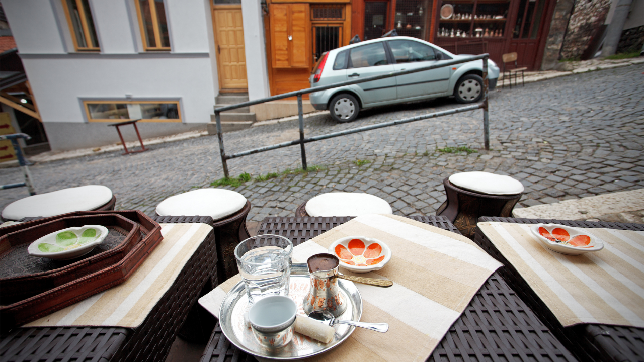 Servicio de café en una terraza junto a una calle de Sarajevo